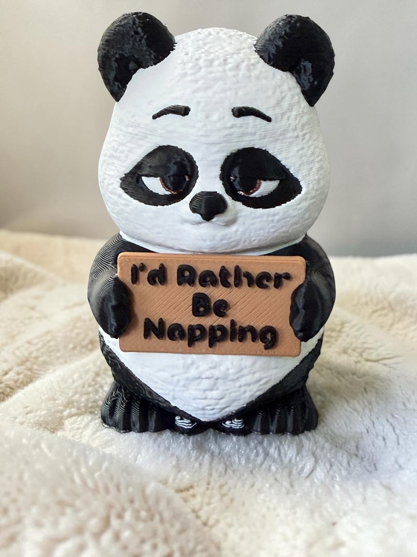 3d printed panda holding a sign that says "Id rather be napping"