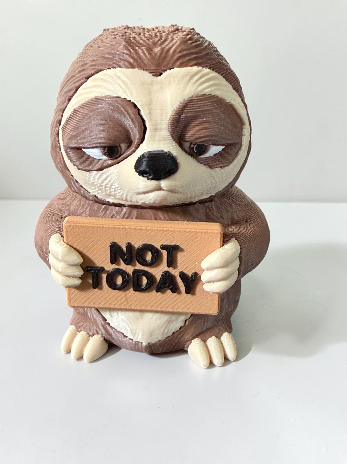 3d printed sloth holding a sign that says "Not Today"