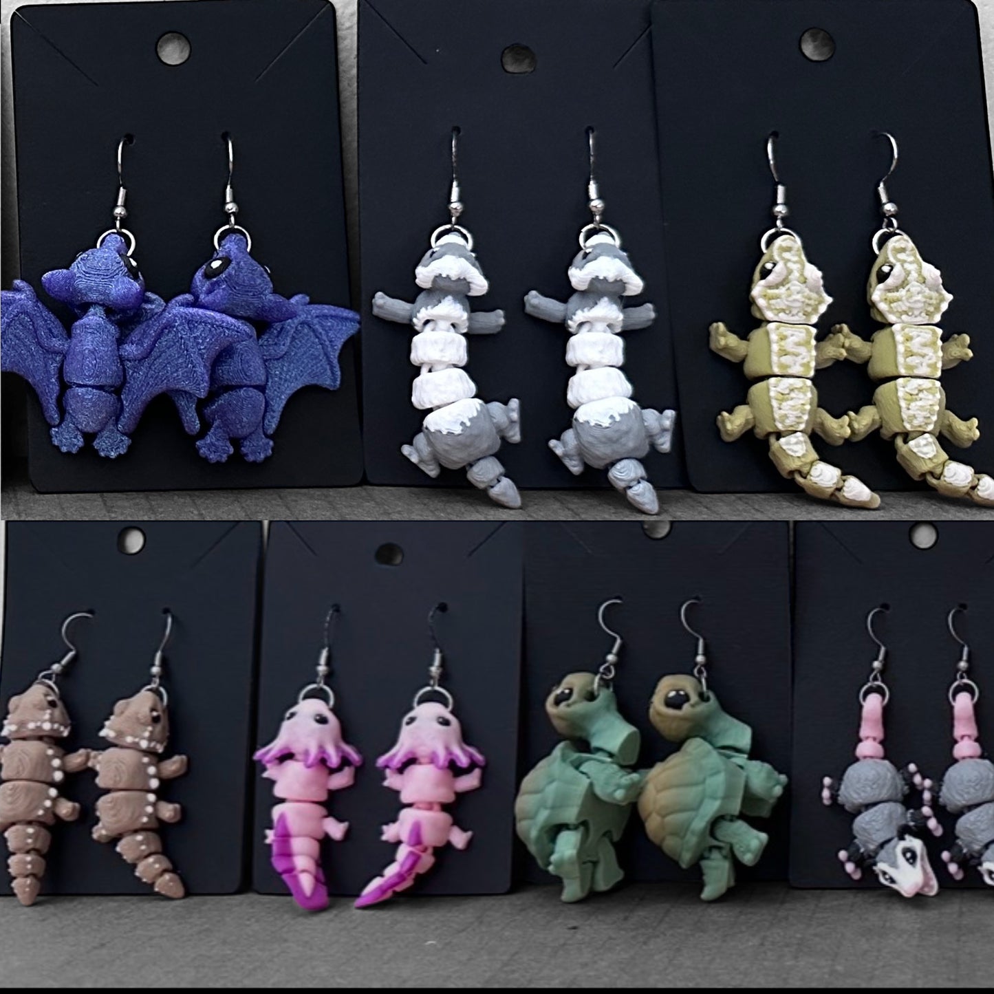 Various animal-shaped earrings on black display cards.