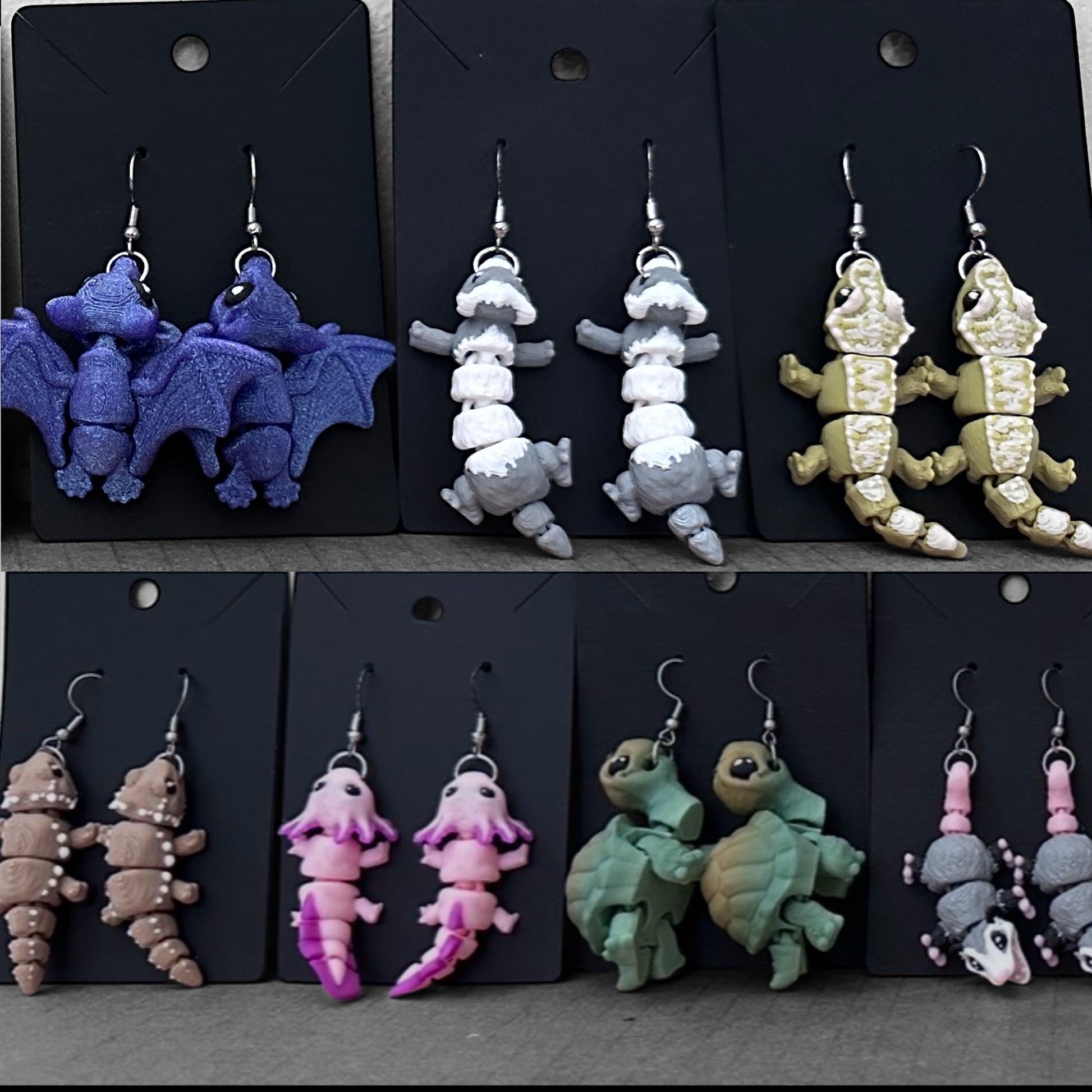 Various animal-shaped earrings on black display cards.