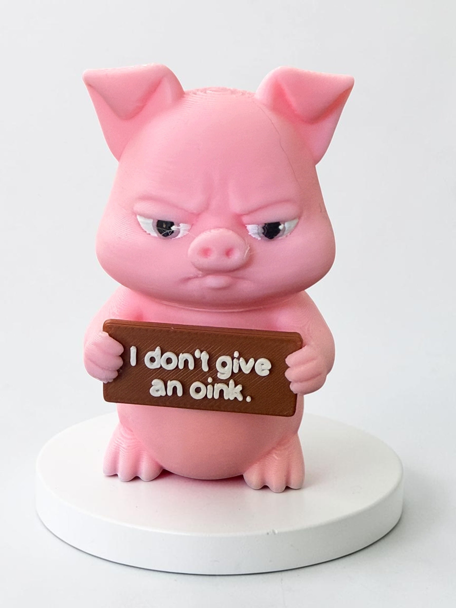 3d printed pink pig holding a sign that says "I don't give an oink"