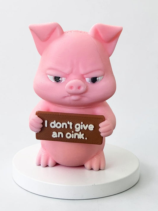 3d printed pink pig holding a sign that says "I don't give an oink"