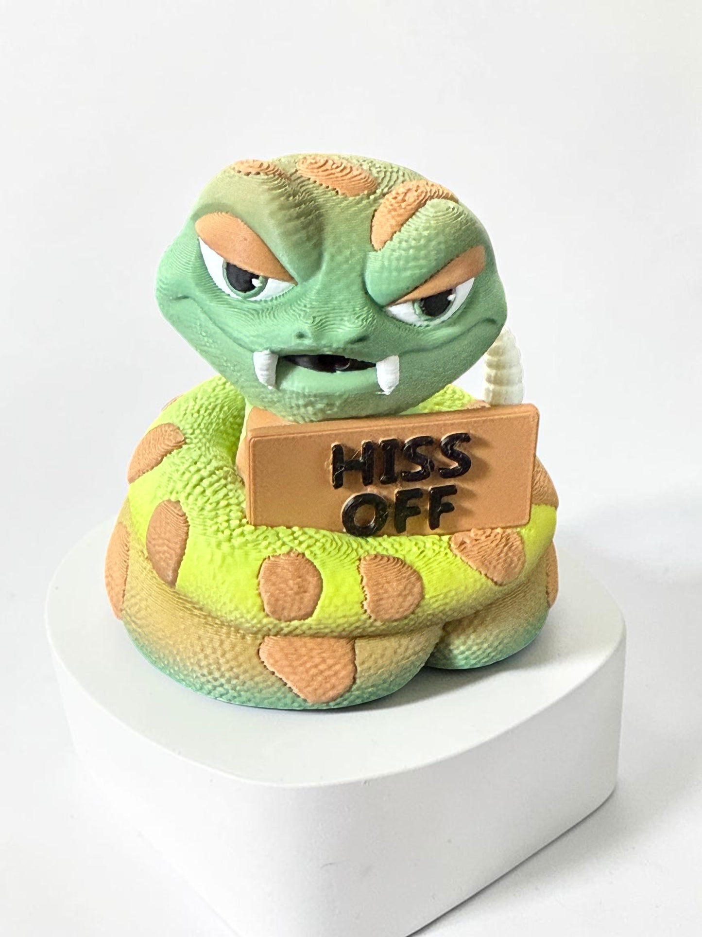 3d printed snake holding a sign that says "Hiss off"