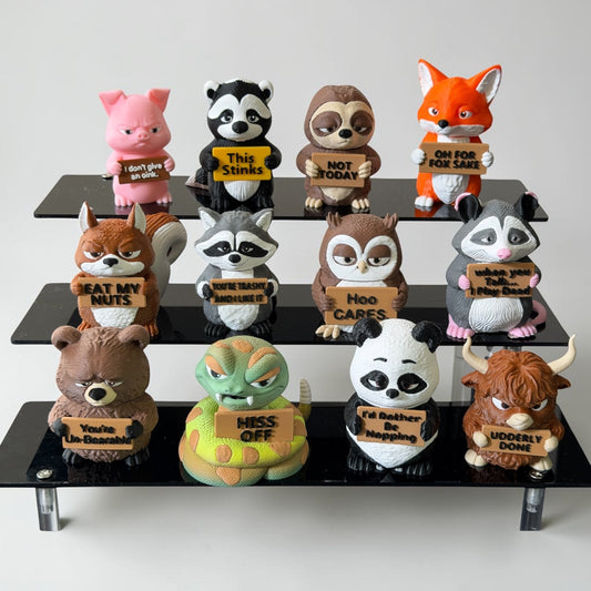 Three tiers of 3d printed animals all holding signs with funny sayings on them